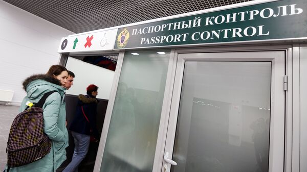 Пассажиры проходят паспортный контроль в аэропорту