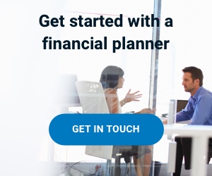 A woman is sitting at a desk, talking to her financial planner